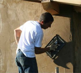 Una persona extendiendo cemento sobre una pared